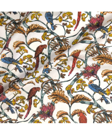 Tissu en percale de coton blanc avec imprimés de perruches rousses, fleurs roses et feuilles de ginkgo jaunes.